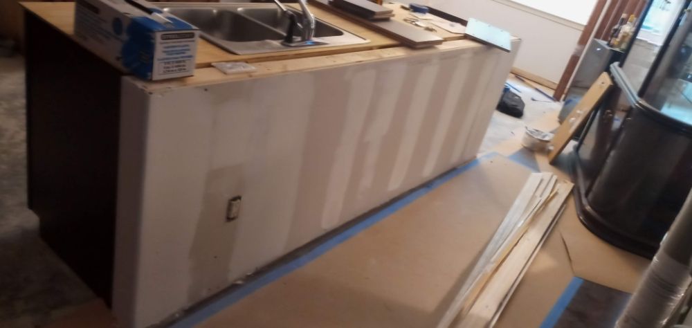 Kitchen island being drywalled before tile